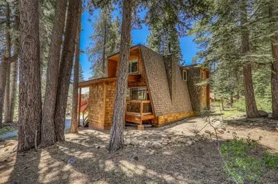 a house in the woods with trees at 10th Mountain Home - 4BR Tahoe Donner w Hot Tub, HOA amenities! in Truckee