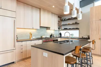 a kitchen with a sink and a counter with stools at Elevation Ski-in, Ski-out in Northstar w Private Hot Tub & HOA Amenities in Truckee