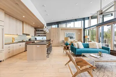 a kitchen and a living room with a blue couch at Elevation Ski-in, Ski-out in Northstar w Private Hot Tub & HOA Amenities in Truckee