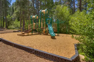 a playground with a slide in a park at Elevation Ski-in, Ski-out in Northstar w Private Hot Tub & HOA Amenities in Truckee