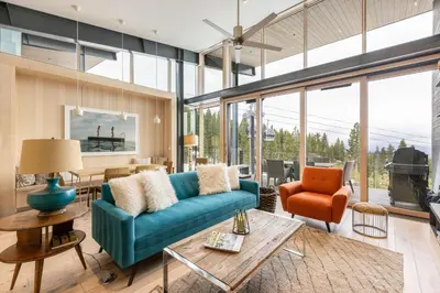 a living room with a blue couch and a table at Elevation Ski-in, Ski-out in Northstar w Private Hot Tub & HOA Amenities in Truckee