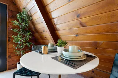 a white table in a room with a wooden wall at Lake Isabella A frames in Lake Isabella