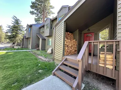 a house with a staircase leading up to a red door at Forest Creek #16 condo in Mammoth Lakes