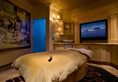 a bird sitting on a bed in a room with a tv at Peppermill Resort Spa Casino in Reno