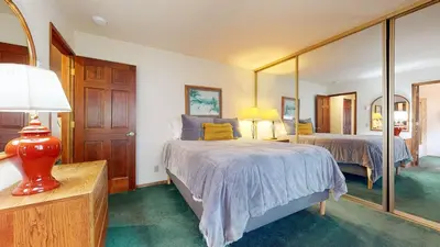 a bedroom with two beds and a large mirror at Mammoth Sierra Townhomes #23 condo in Mammoth Lakes