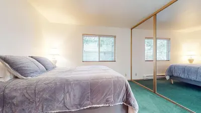 a bedroom with a bed and a mirror at Mammoth Sierra Townhomes #23 condo in Mammoth Lakes