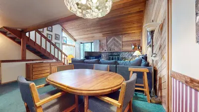 a living room with a table and a couch at Mammoth Sierra Townhomes #23 condo in Mammoth Lakes