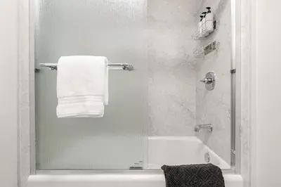 a bathroom with a shower with a tub and a towel at Mountain View Apartment in North Fork