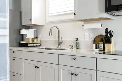 a kitchen with white cabinets and a sink at Mountain View Apartment in North Fork