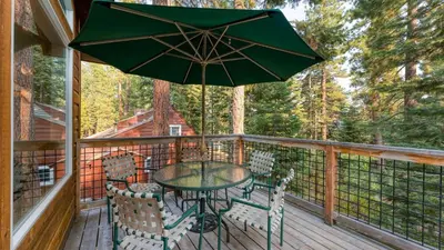 a table and chairs on a deck with an umbrella at Tahoe Vista by AvantStay Central Location Patio in Tahoe Vista