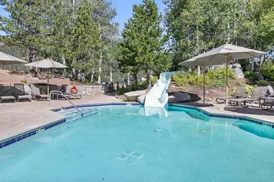 a swimming pool with a slide in the middle at Everline Resort and Spa 1BR Suite with Fireplace in Olympic Valley