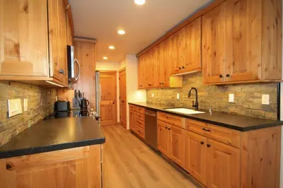 a large kitchen with wooden cabinets and black counter tops at Tamarack 39 in Mammoth Lakes