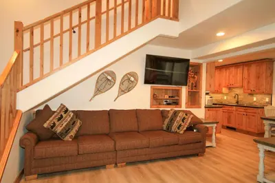 a living room with a couch and a staircase at Tamarack 39 in Mammoth Lakes