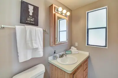 a bathroom with a sink and a toilet and a mirror at La Grange Home with Covered Patio and Gas Grill! in La Grange