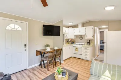 a kitchen with white cabinets and a table with chairs at La Grange Home with Covered Patio and Gas Grill! in La Grange