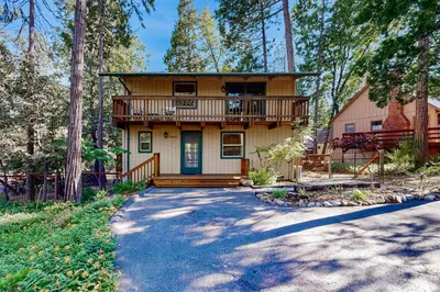 a large house with a balcony in the woods at Walk to Golf and Restaurants Serene Twain Harte Gem in Twain Harte
