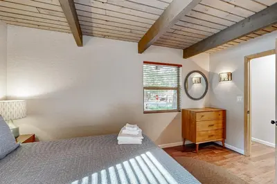 a bedroom with a bed and a dresser and a window at Walk to Golf and Restaurants Serene Twain Harte Gem in Twain Harte