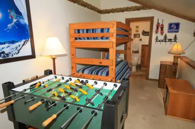 a bedroom with a foosball table and a bunk bed at Mountainback 68 2 bedroom with loft in Mammoth Lakes