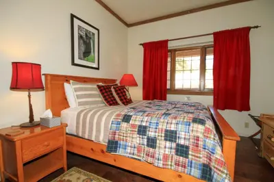 a bedroom with a bed and a window with red curtains at Mountainback 68 2 bedroom with loft in Mammoth Lakes