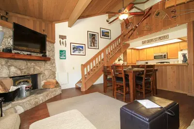 a living room with a fireplace and a table with chairs at Mountainback 68 2 bedroom with loft in Mammoth Lakes