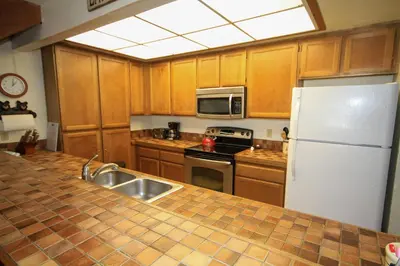 a kitchen with a sink and a white refrigerator at Mountainback 68 2 bedroom with loft in Mammoth Lakes