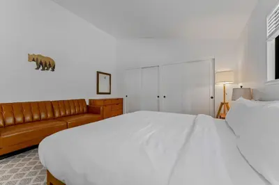 a bedroom with a large white bed and a couch at Modern 3BR Carnelian Bay Retreat in Carnelian Bay