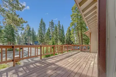 a home with a wooden deck with trees in the background at Modern 3BR Carnelian Bay Retreat in Carnelian Bay