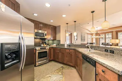 a kitchen with wooden cabinets and stainless steel appliances at Big Horn Lodge 206 by East West in Truckee