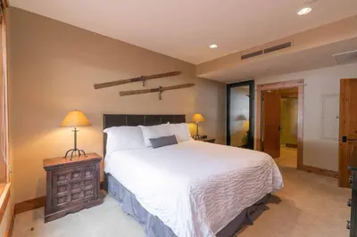 a bedroom with a large white bed and a night stand at Big Horn Lodge 206 by East West in Truckee