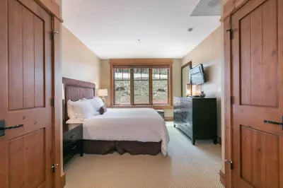 a bedroom with a large bed and a window at Big Horn Lodge 208 by East West Hospitality in Truckee