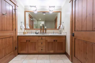 a bathroom with a sink and a large mirror at Big Horn Lodge 301 by East West Hospitality in Truckee