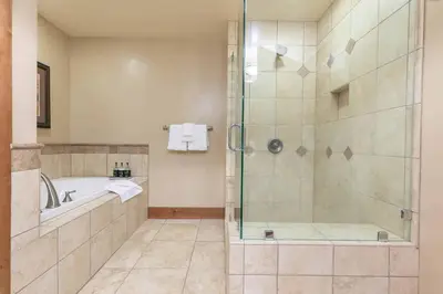 a bathroom with a shower and a tub and a sink at Big Horn Lodge 301 by East West Hospitality in Truckee