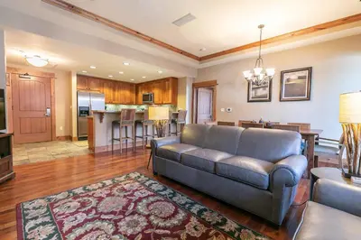 a living room with a couch and a kitchen at Big Horn Lodge 301 by East West Hospitality in Truckee