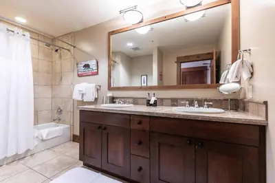 a bathroom with two sinks and a large mirror at Big Horn Lodge 305 by East West Hospitality in Truckee