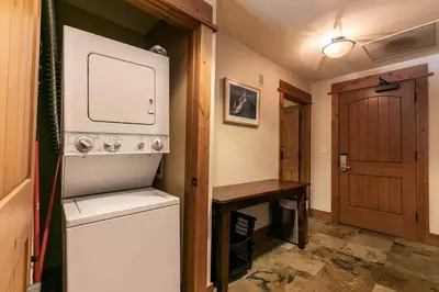 a kitchen with a refrigerator and a wooden door at Big Horn Lodge 305 by East West Hospitality in Truckee
