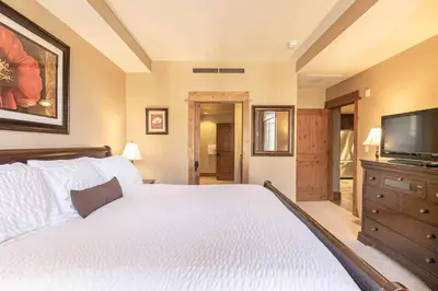 a bedroom with a bed and a flat screen tv at Big Horn Lodge 309 by East West Hospitality in Truckee