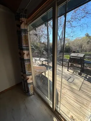 a room with a sliding glass door with a view of a deck at Sequoia River Front Cabins in Three Rivers