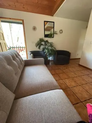 a living room with a couch and a large window at Sequoia River Front Cabins in Three Rivers
