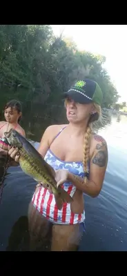 a woman holding a fish in the water at Sequoia River Front Cabins in Three Rivers