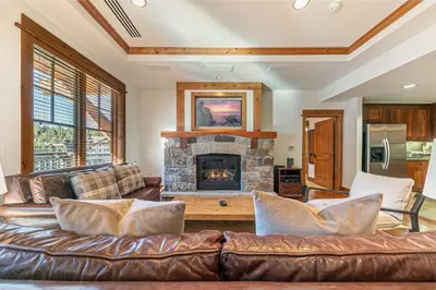 a living room with a leather couch and a fireplace at Big Horn Lodge 404 by East West Hospitality in Truckee