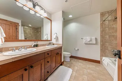 a bathroom with a sink and a toilet and a mirror at Big Horn Lodge 404 by East West Hospitality in Truckee
