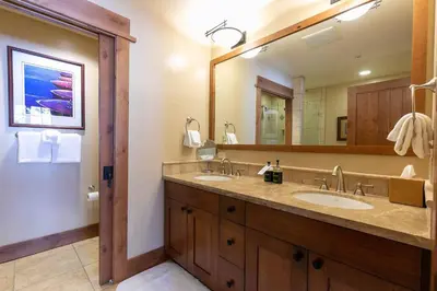 a bathroom with two sinks and a large mirror at Big Horn Lodge 404 by East West Hospitality in Truckee