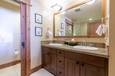 a bathroom with two sinks and a large mirror at Big Horn Lodge 310 by East West Hospitality in Truckee
