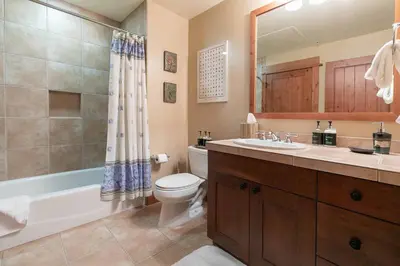 a bathroom with a toilet and a sink and a shower at Big Horn Lodge 310 by East West Hospitality in Truckee