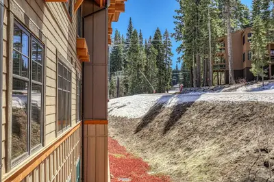 a house with a dirt road next to a building at Big Horn Lodge 310 by East West Hospitality in Truckee