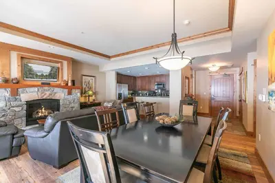 a dining room and living room with a table and a fireplace at Big Horn Lodge 310 by East West Hospitality in Truckee