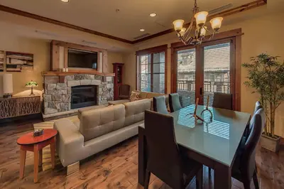 a living room with a table and a couch and a fireplace at Big Horn Lodge 403 by East West Hospitality in Truckee