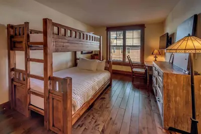 a bedroom with a bunk bed and a desk at Big Horn Lodge 403 by East West Hospitality in Truckee