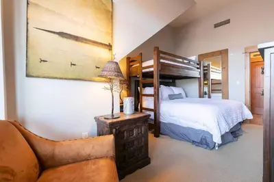 a bedroom with a bunk bed and a couch at Big Horn Lodge 501 by East West Hospitality in Truckee