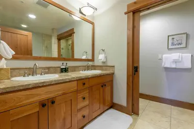 a bathroom with two sinks and a large mirror at Big Horn Lodge 501 by East West Hospitality in Truckee